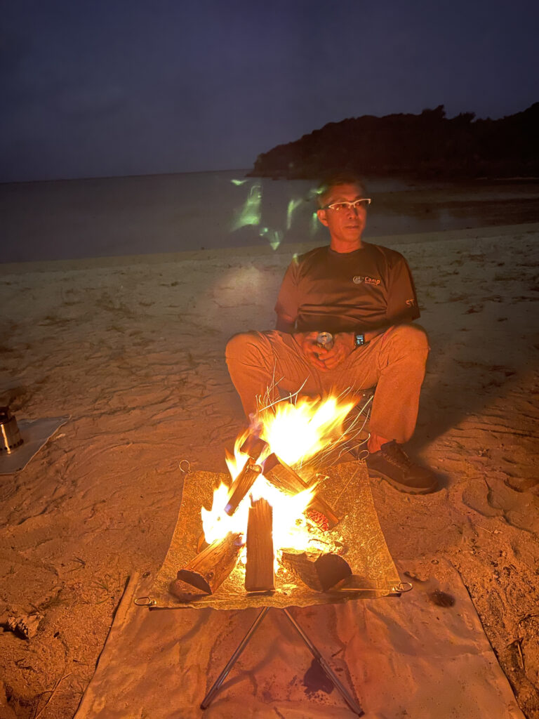 リトリート沖縄のプロデューサー・相川浩一が焚き火を眺めている写真
